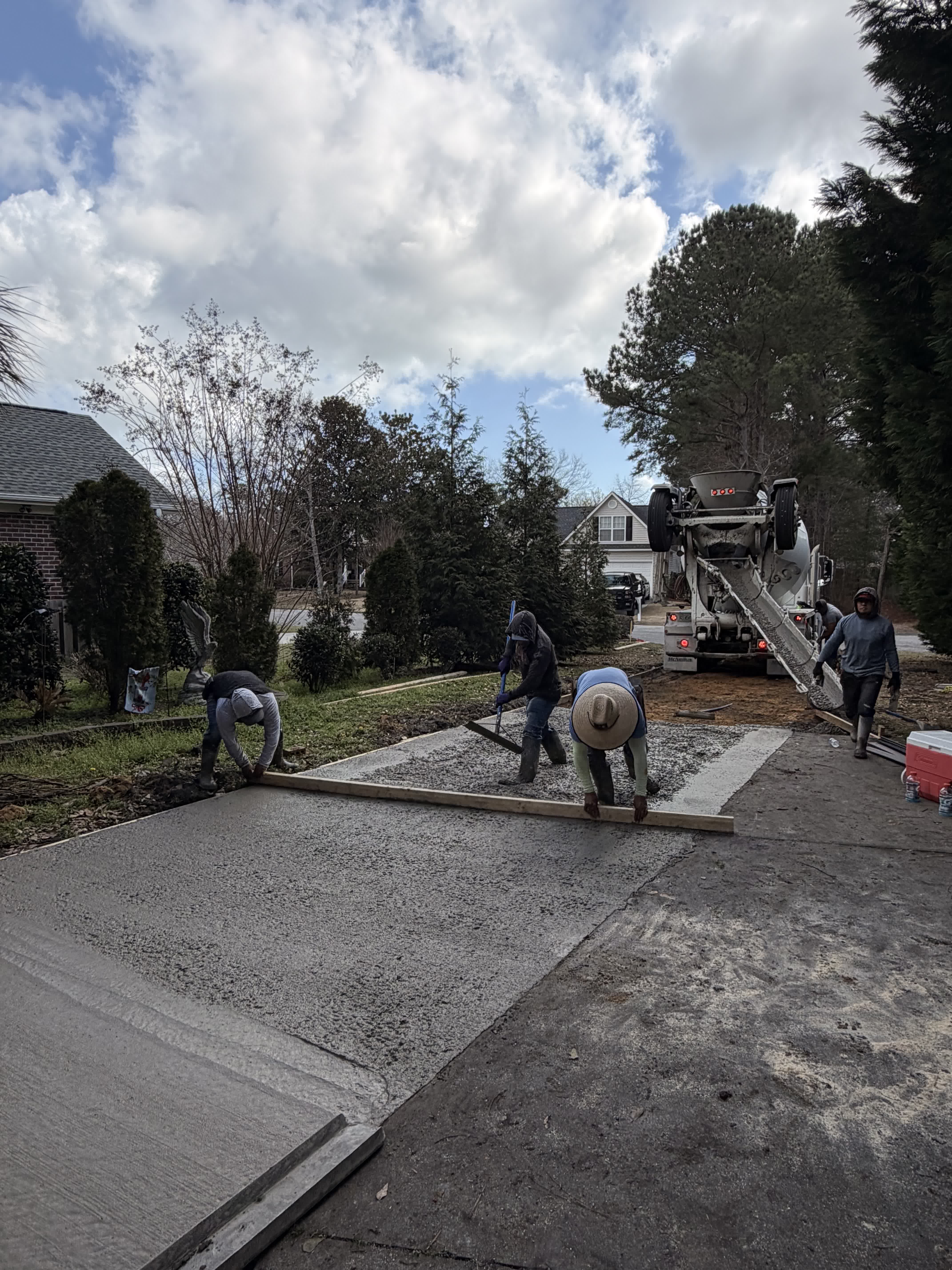 Crew pouring concrete driveway