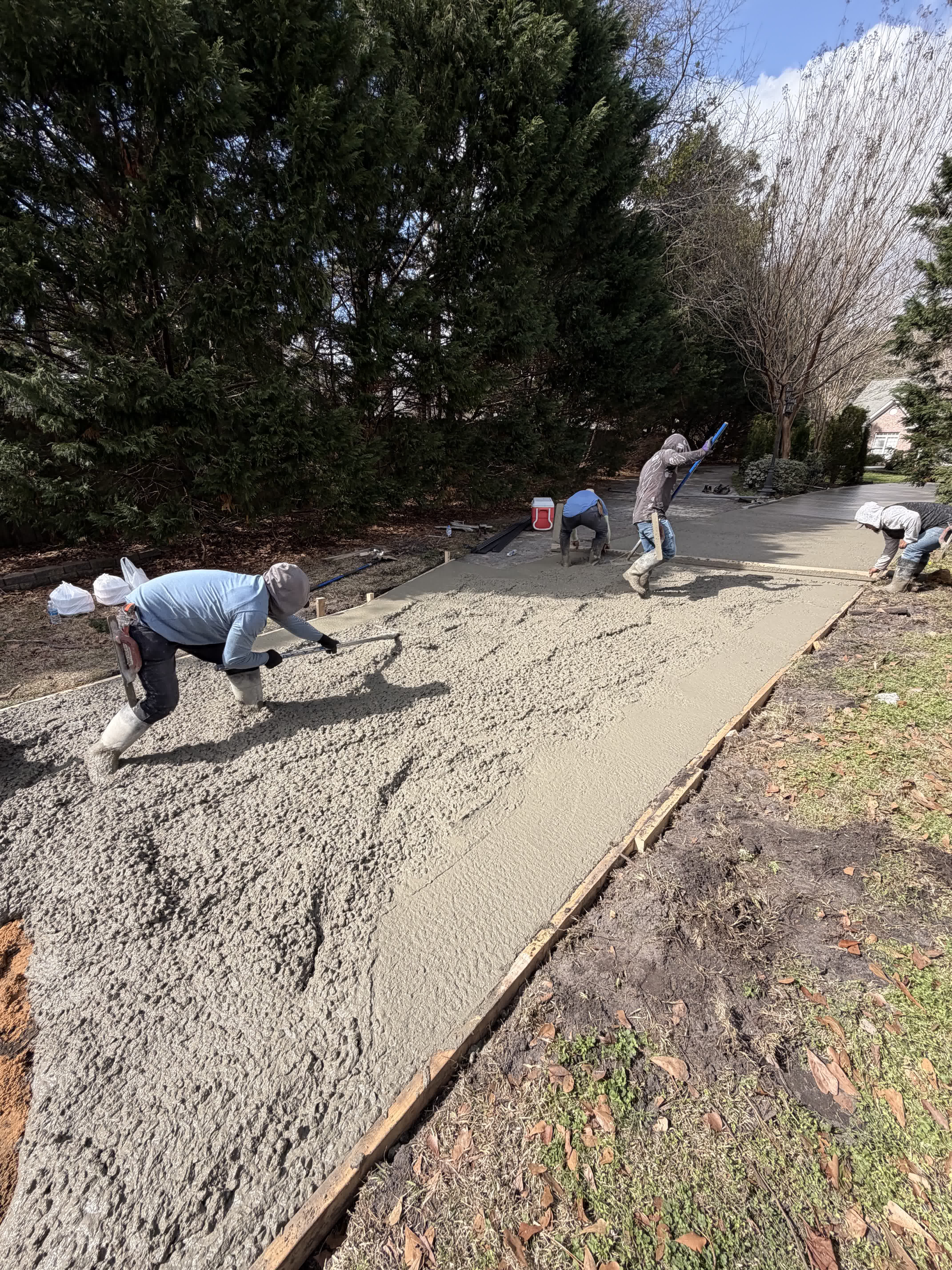 Crew finishing concrete surface